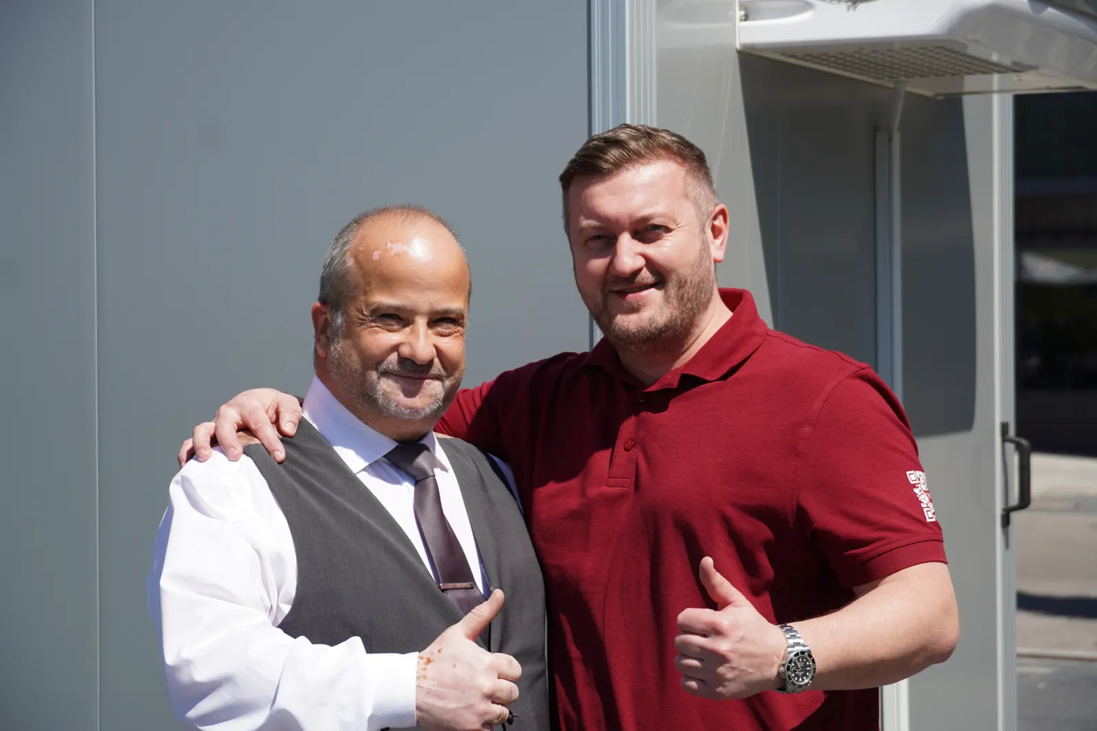 Husein und Martin vor einem Anhänger